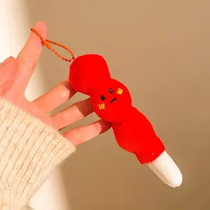 Détail d'un pendentif en peluche rouge avec visage mignon et chaîne à billes orange