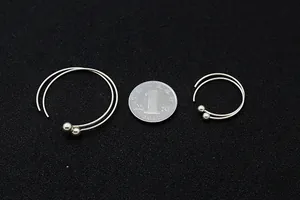 Confronto dettagliato di orecchini a cerchio in argento S925 con sfere di metallo e moneta