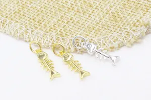 Détails macro des breloques arêtes de poisson en argent S925, finitions or et argent
