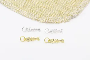 Vue macro détaillée des breloques en forme d'arête de poisson en argent S925 et doré