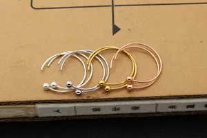 Vista macro di orecchini a cerchio a C in argento S925 nei colori argento, oro e oro rosa
