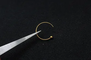 Vista macro di ganci per orecchini in argento S925 dorato con sfera e pinzette inox
