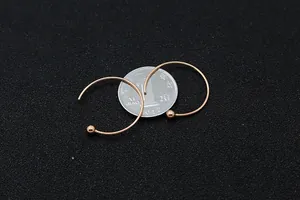 Dettaglio di orecchini a cerchio in argento S925 oro rosa con decorazione a sfera