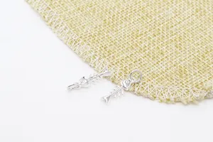 Vue détaillée de breloques d'arêtes de poisson en argent pour colliers DIY sur lin