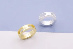 Vista macro di anelli cavi in argento sterling S925 con finiture argento e oro