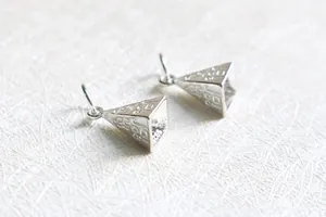 Macro detail of S925 sterling silver pyramid pendant with fine geometric engravings