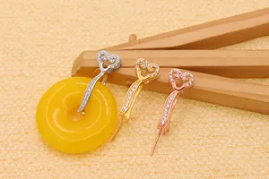 Detailed view of silver, gold and rose gold heart-shaped pendant bails with pavé stones