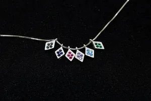 Close-up of S925 sterling silver rhombic pendants with colorful zircon inlay on a fine chain