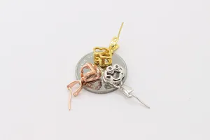 Gros plan d'attaches de bijoux en argent S925 en forme de trèfle, coloris or et or rose