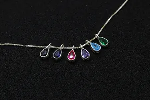 Macro detail of S925 silver necklace with six colorful teardrop zircon pendants