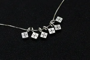 Close-up of S925 sterling silver geometric square pendants showing the hallmark stamp