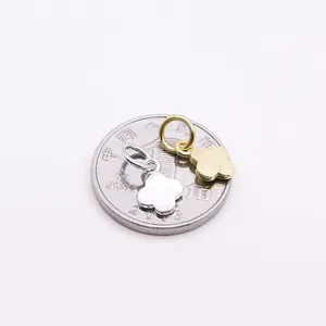 S925 Kleeblatt-Anhänger aus Sterlingsilber in Gold und Silber neben einer Münze