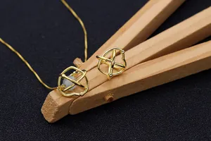 Detailaufnahme eines goldenen Nest-Anhängers mit einer eleganten Perle im Inneren