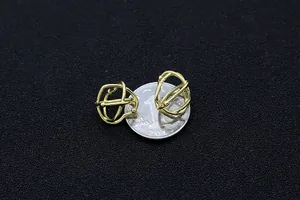Nahaufnahme goldener hohler Kugelanhänger auf einer Münze für feine Handwerksdetails