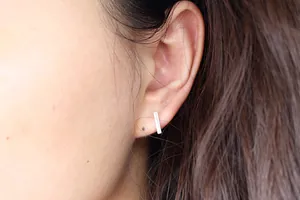 Close-up of minimalist S925 sterling silver rectangular bar stud earrings on a model