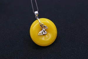 Detalle macro del cierre de mariposa en plata S925 sobre colgante de ámbar amarillo