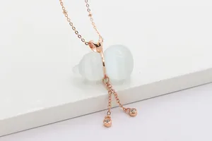 Nahaufnahme von roségoldenem Flaschenkürbis-Anhänger mit Katzenauge und Quasten
