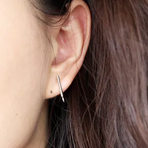 Minimalist S925 sterling silver bar stud earrings with loop worn on model earlobe