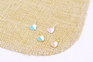 Detailweergave van mini hartvormige hangers met emaille op een jute achtergrond