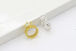 Dettaglio macro di anelli in argento S925 con trama a perline e montatura a quattro griffe