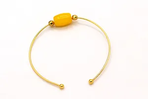 Detail of S925 silver gold-plated cuff bracelet with amber bead and screw ball ends