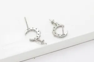 Detalle de monturas de pendientes de luna en plata S925 con incrustaciones