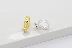 Vista macro di ciondoli a corona in oro e argento con zirconi per creazioni di gioielli DIY