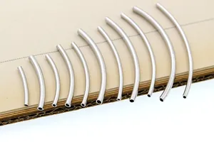 Detailed view of curved silver-plated hollow tubes for DIY jewelry bracelet making
