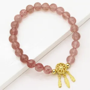 Roze aardbeienkwarts kralenarmband met gouden dromenvanger bedeltje en verenhangers
