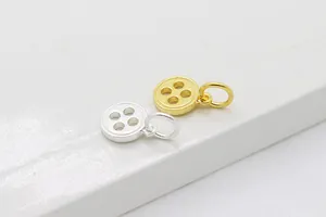 Vue macro de breloques en forme de boutons en argent et or avec design à quatre trous