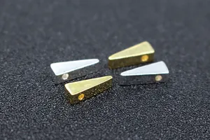 Close-up of polished S925 silver and gold triangular spacer beads for DIY jewelry