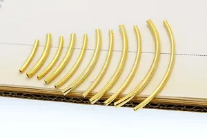 Macro view of 11 different lengths of golden S925 sterling silver curved tube beads