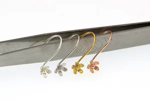 Macro view of S925 sterling silver flower ear hooks in four metallic plating finishes