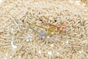 Detail showing S925 sterling silver floral ear hooks in silver, gold, and rose gold finishes