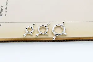 Drei Größen von S925 Sterlingsilber Federringen auf einem Buch mit Metallstempeldetails