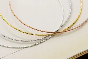 Dettaglio di bracciali regolabili in argento S925 con texture diamantata brillante e sottile