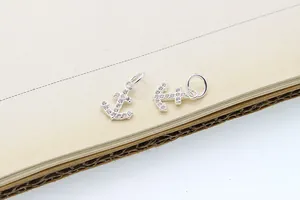 Dettaglio dei ciondoli ad ancora in argento S925 con micro-pave di pietre di zircone