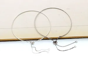 Close-up of adjustable S925 silver bangles featuring sliding bead claps and tassels