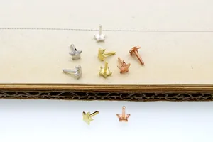 Macro detail of S925 sterling silver star-shaped stud pins in silver, gold, and rose gold