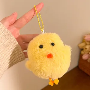 Close-up of yellow plush chick keychain with soft faux fur and orange feet details