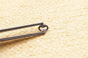 Macro shot of S925 sterling silver oval jewelry tag with Italy hallmark engraving