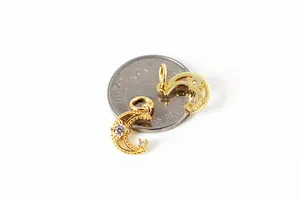 Macro shot of S925 sterling silver crescent moon charm with zircons and size coin reference