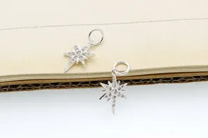 Dettaglio di pendenti a stella in argento S925 con pavé di zirconi cubici scintillanti