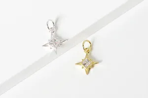 Detailed view of silver and gold star charms with cubic zirconia for DIY bracelets