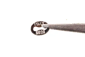 Macro shot of S925 sterling silver oval jewelry tag with Italy hallmark engraving