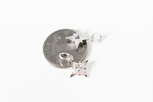 Detailed view of S925 sterling silver star pendant with zircon next to a coin for scale