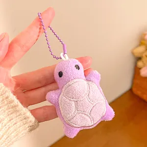 Detail of purple plush turtle keychain with embroidered shell texture and bead chain