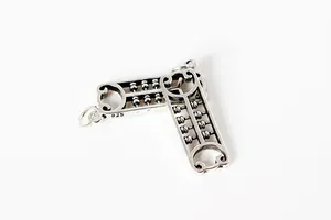 Détail macro de pendentifs bouclier abaque en argent S925 avec finition vintage et poinçon