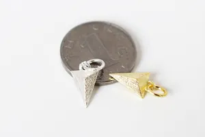 Détails macro de pendentifs triangulaires givrés en or et argent avec échelle de taille