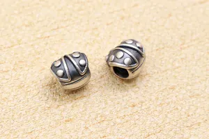 Makrodetail eines antiken 3D-Silberkäfer-Charms mit gepunkteter Textur für DIY-Schmuck
